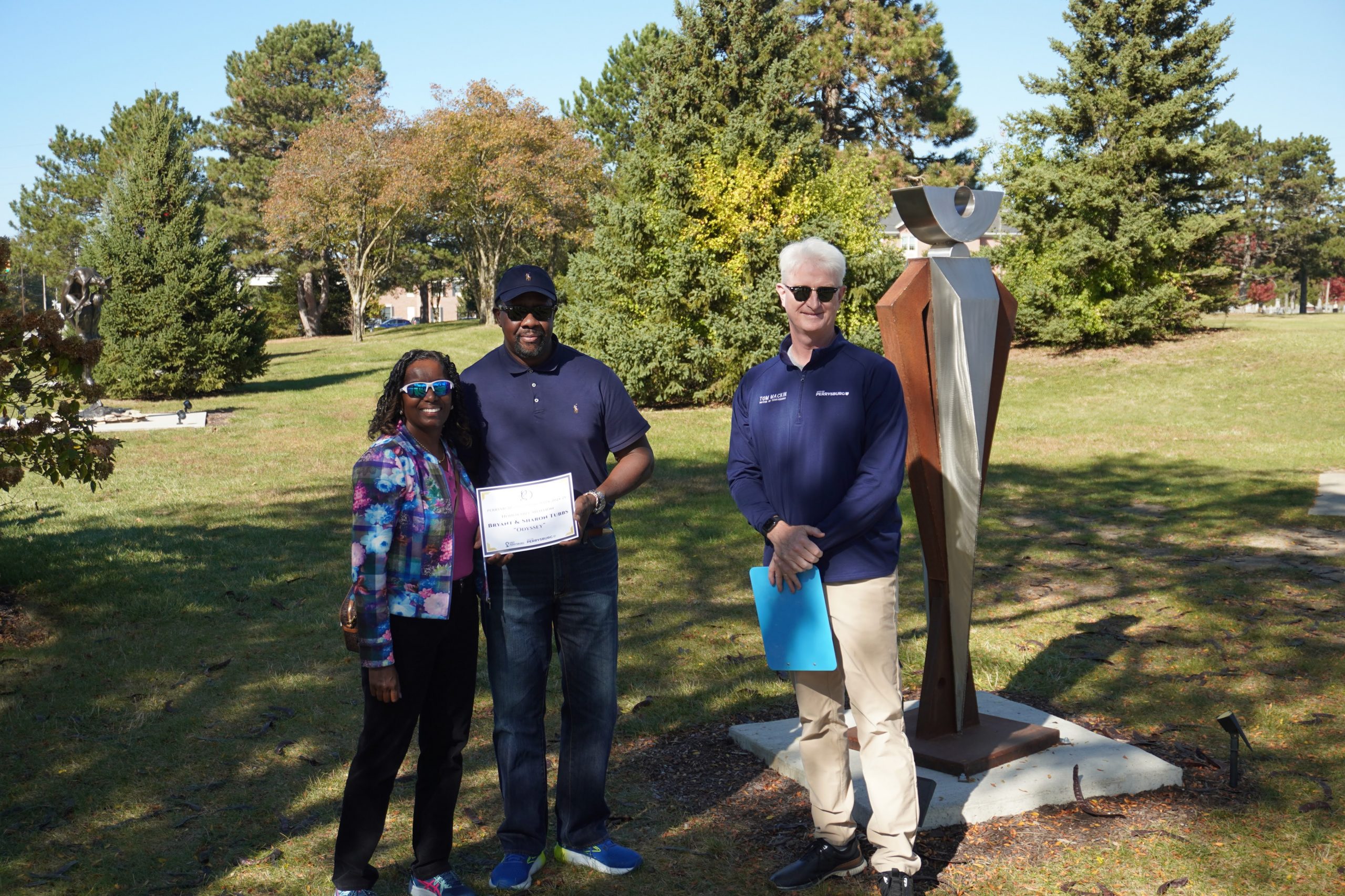 Bryant and Sharon Tubbs with Perrysburg Ohio Mayor Tom Mackin beside their sculpture Odyssey